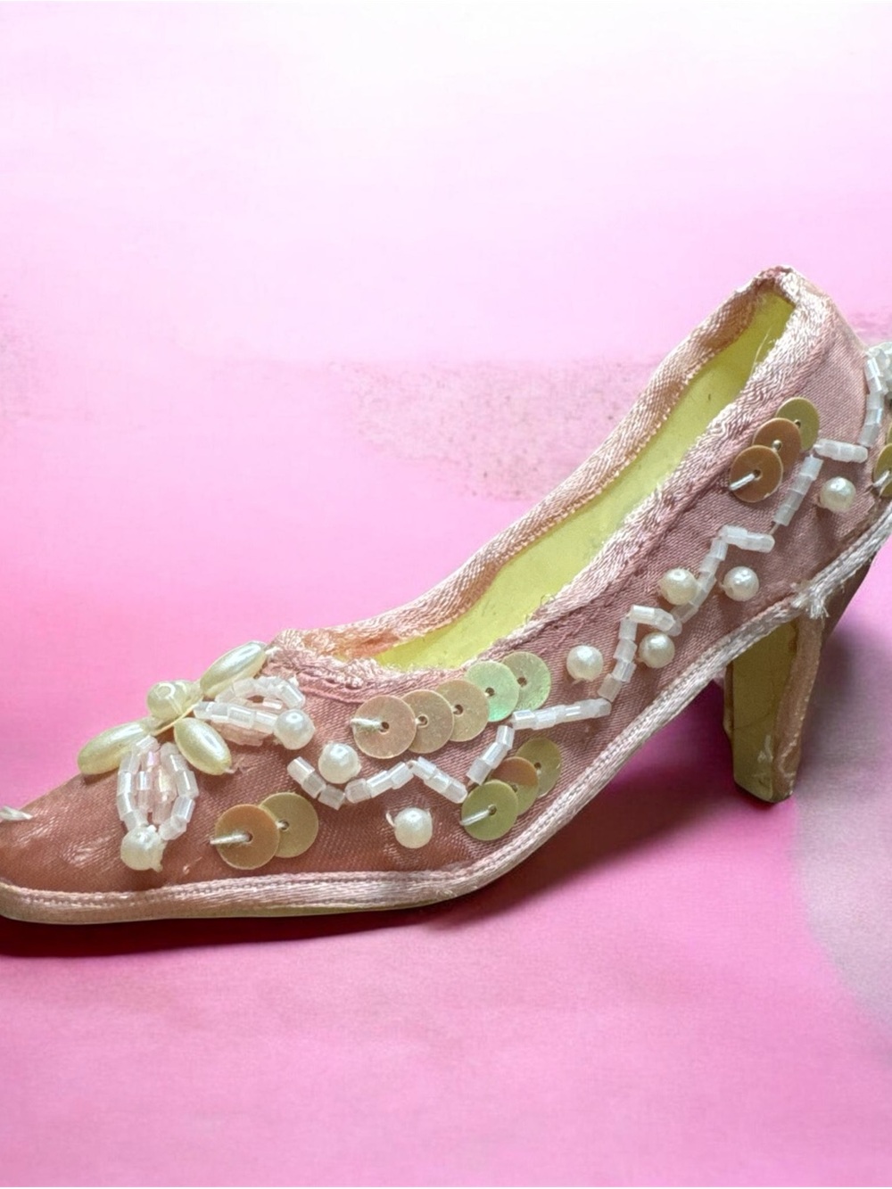Victorian-era collectible velvet pump with ornate pink embellishments.